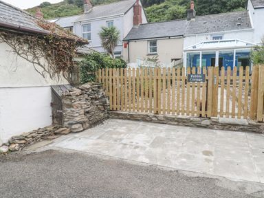 An outdoor area with a sign for Pebble Cottage in Portreath