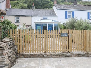 A garden area with a fenced entrance at Pebble Cottage in Portreath