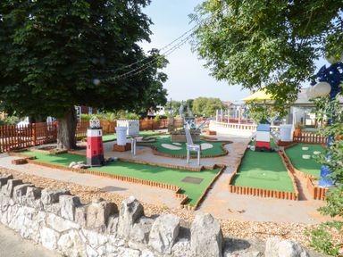 An outdoor mini golf course with miniature lighthouses windmills and trees at Sea Breeze in Rhos-on-Sea