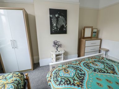 A bedroom with a bed and wardrobe at Sea Breeze in Rhos-on-Sea
