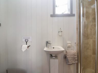 A bathroom with a sink and shower at The Shepherds Hut in Chippenham