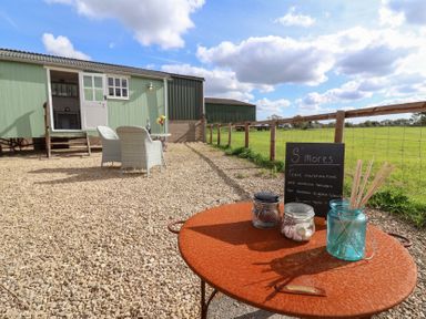 An outdoor area with a table and chairs at The Shepherds Hut in Chippenham