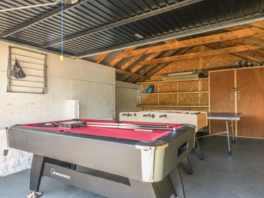 A game room with a pool table foosball table and ping pong table in a garage at The Coach House in Teignmouth