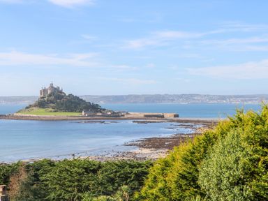 A coastal view with a castle on an island and greenery in the foreground at The Stables in Longrock