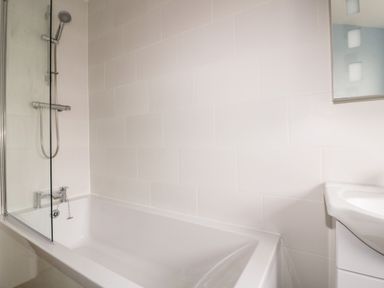 A bathroom with a bathtub shower and a sink at Avalon in St Agnes
