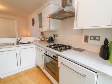 A kitchen with a sink stove oven countertop and cabinets at Seashore in Woolacombe