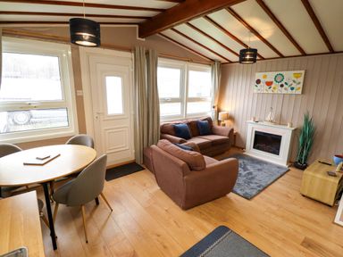 A living room with a sofa and dining table at Moggs Retreat in Chapel St Leonards