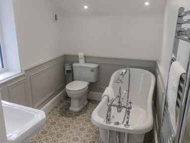 A bathroom with a freestanding bathtub toilet sink and towel rack at Station House in Scarborough