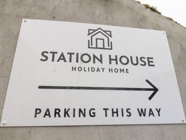 A sign on a wall indicating parking direction for Station House holiday home in Scarborough