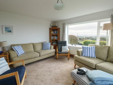 A living room with sofas and a bookshelf at Yr Orsedd in Llanfaethlu