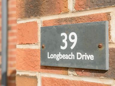 A house number sign displaying 39 Longbeach Drive mounted on a brick wall at 39 Longbeach Drive in Beadnell