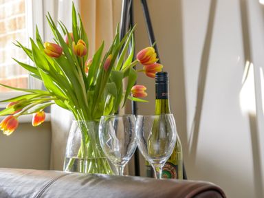 A vase with tulips next to two empty wine glasses and a bottle of wine at 39 Longbeach Drive in Beadnell