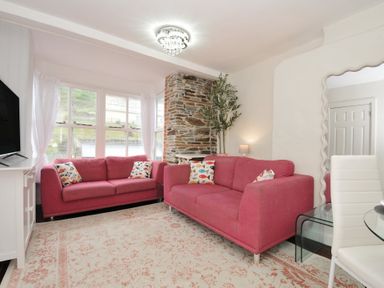 A living room with a sofa and television at Stargazy in Trebarwith Strand near Tintagel