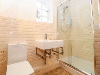 A bathroom with a toilet sink and glass shower enclosure at The Old School in Downham Market