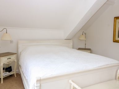 A bedroom with a white bed and two bedside tables with lamps at The Old School in Downham Market
