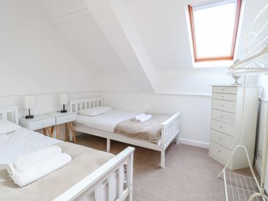A bedroom with two single beds a chest of drawers and a skylight window at The Old School in Downham Market
