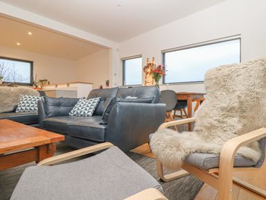 A living room with leather sofas a wooden coffee table and a dining table with chairs at Idlewild 2 Wheal Turnavore in St Agnes