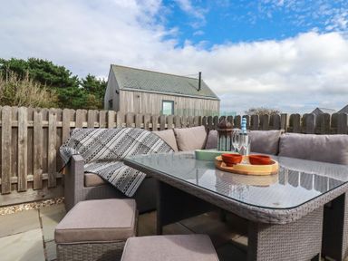 An outdoor seating area with a table and couch at Idlewild, 2 Wheal Turnavore, St Agnes