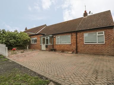 A single-story brick house with a tiled roof and a paved driveway at 2 The Close in Robin Hoods Bay