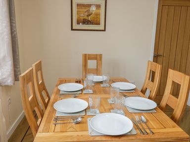 A dining table set with plates glasses and cutlery in a dining room at Ryedale Country Lodges - Hazel Lodge Kirkbymoorside