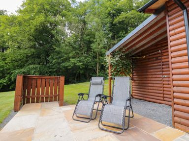 An outdoor area with lounge chairs and a wooden fence at Ryedale Country Lodges - Hazel Lodge Kirkbymoorside