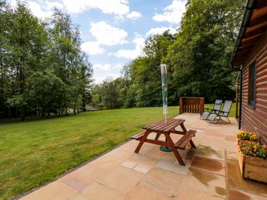 A garden with a table, chairs and a flower box at Ryedale Country Lodges - Hazel Lodge Kirkbymoorside