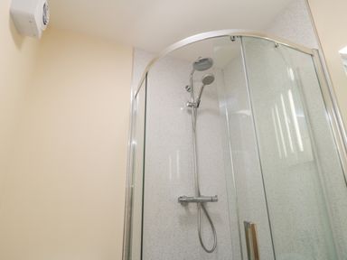 A bathroom shower enclosure with a glass door and chrome shower fixtures at Ryedale Country Lodges - Willow Lodge in Kirkbymoorside
