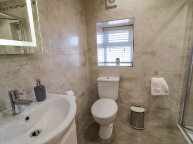 A bathroom with a toilet sink mirror window and towel at Lough Island Reavy Cottage Kilcoo Mourne Mountains Newry County Down
