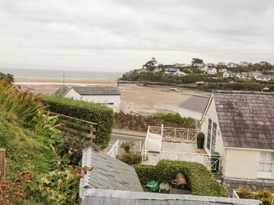 A coastal view with houses and a sandy beach in the background at Castell in Abersoch