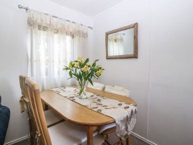 A dining room with a table and chairs at Castell Chalet in Penrhos near Pwllheli