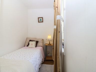 A bedroom with a bed and a lamp at Castell Chalet in Penrhos near Pwllheli