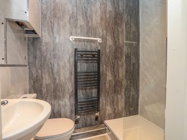 A bathroom with a sink toilet heated towel rack and a shower at Gadlys House - Waters Edge in Beaumaris