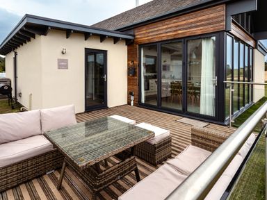 An outdoor patio area with a sofa and coffee table at Cowslip in Bamburgh