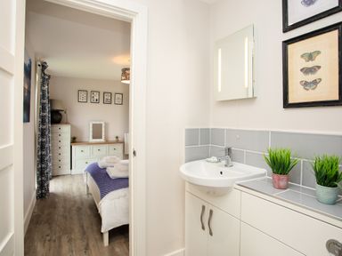 A bathroom with a sink and mirror at Cowslip in Bamburgh