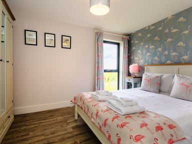 A bedroom with a bed and wardrobe at Cowslip Bamburgh