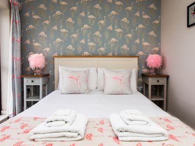 A bedroom with a bed and bedside tables at Cowslip in Bamburgh