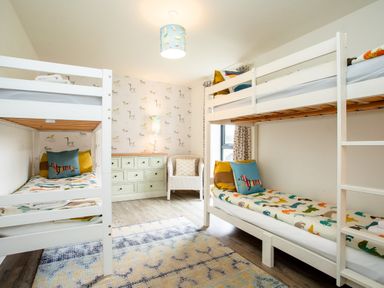A bedroom with bunk beds and a dresser at Cowslip in Bamburgh
