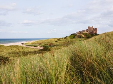 A beach with a castle in the background at Betony in Bamburgh