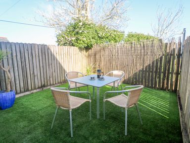 A garden with a table and four chairs at Sunflower Cottage in St Issey