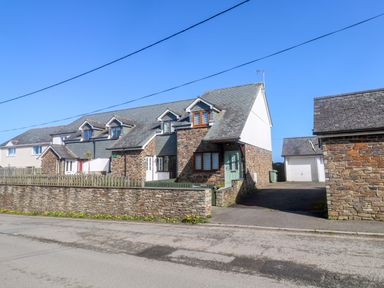 A house with a garage and driveway at Sunflower Cottage St Issey