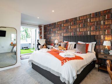 A bedroom with a double bed and bedside tables with lamps at Bear Cottage in Chacewater near Truro
