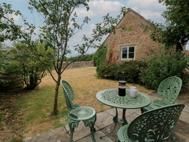 A garden with a table and chairs at The Lodge at Mortons in Hankerton