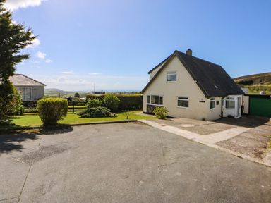 A house with a garage and driveway at Pen Y Garth in Mynytho near Llanbedrog