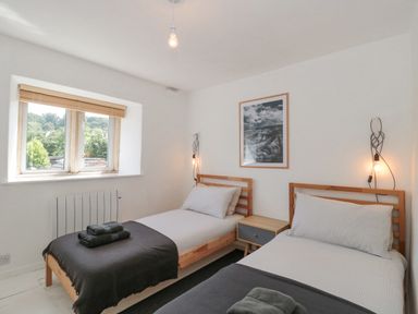 A bedroom with two single beds and a window at Abbey Cottage Montacute
