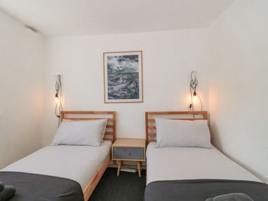 A bedroom with two single beds and a nightstand between them at Abbey Cottage Montacute