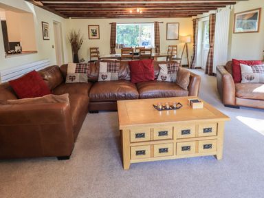 A living room with leather sofas and a wooden coffee table at Ellerbeck Bridge in Underbarrow near Kendal