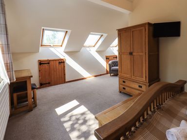A bedroom with wooden furniture and skylight windows at Ellerbeck Bridge in Underbarrow near Kendal