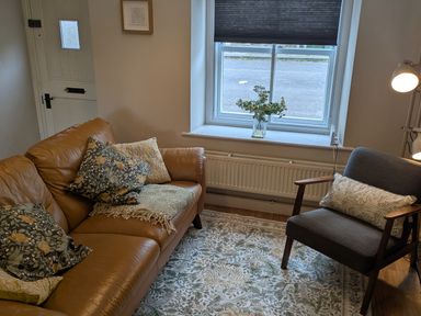 A living room with a sofa and chair at Troopers Cottage in Frome