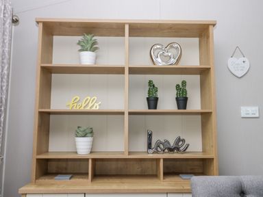 A wooden shelving unit with potted plants and decorative items in a room at Cayton Pines Cayton Bay near Scarborough