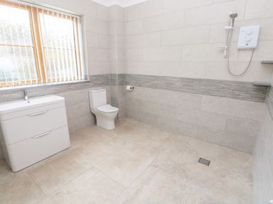 A bathroom with a sink cabinet a toilet a window with blinds and a walk-in shower at Grooms Quarters at Pant y Gaseg Farm in Ammanford